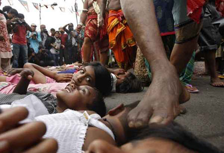 نگاه دختر به هندویی که برای سلامتی کودکان با پا سرشان را لمس میکند