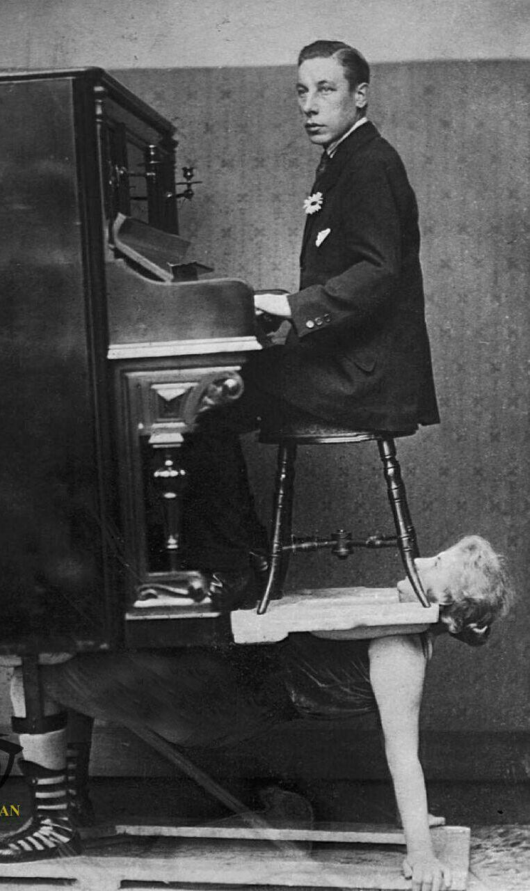 عکس یک زن که در سیرک کار می کرد، در سال ۱۹۲۰، یک پیانو و نوازنده آن را بر روی سینه خودش نگه داشت.